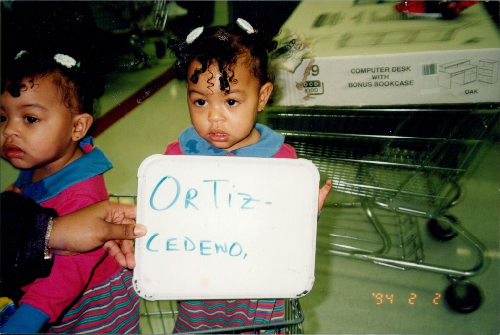 Keyanna as a toddler, holding a whiteboard up with her last name, Ortiz-Cedeño, on it. Courtesy photo.