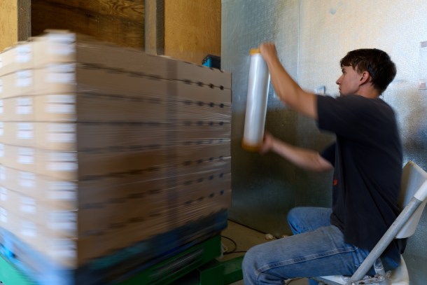 Spork Food Hub employee Niko Bannikov operates the wrapping machine, encasing produce pallets in plastic before loading them onto trucks for delivery. (Photo by Fred Greaves)
